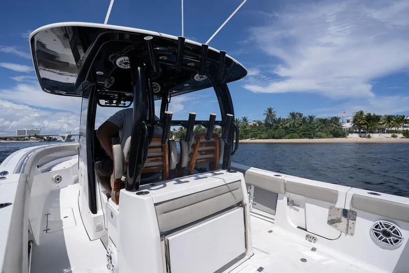 Slide: The Image of 2023 Sportsman Open 322 Center Console boat on water near tropical shoreline. - 40