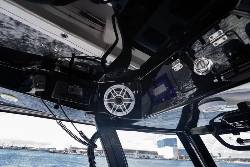 Slide: The Image of 2023 Sportsman Open 322 Center Console interior with speaker and control panel, overlooking waterfront. - 43