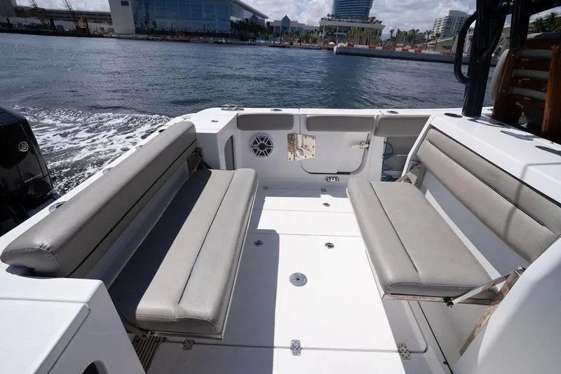 Slide: The Image of 2023 Sportsman Open 322 Center Console boat interior with cushioned seating and waterfront view. - 49