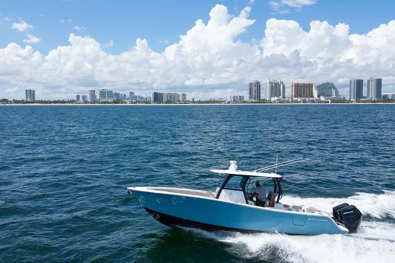 Slide: The Image of 2023 Sportsman Open 322 Center Console boat cruising near city skyline. - 9