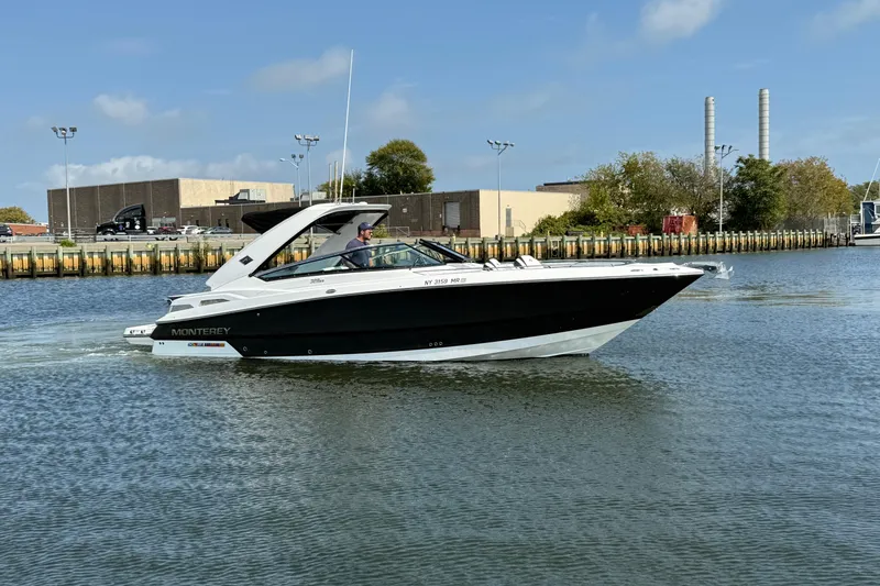 Slide: The Image of 2018 Monterey 328SS Super Sport boat cruising on a calm waterway. - 2