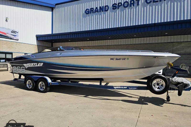 Slide: The Image of 2010 Hustler 266 Classic speedboat on trailer outside Grand Sport Center. - 13