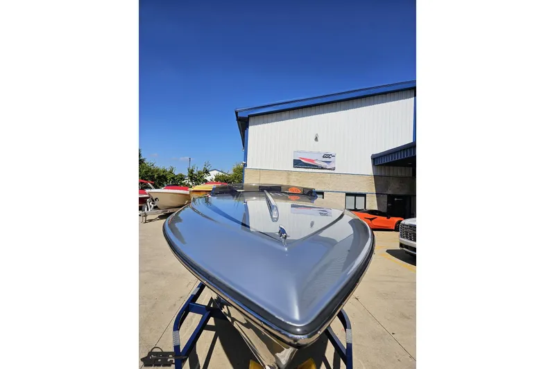 Slide: The Image of 2010 Hustler 266 Classic boat displayed outdoors under clear blue sky. - 16