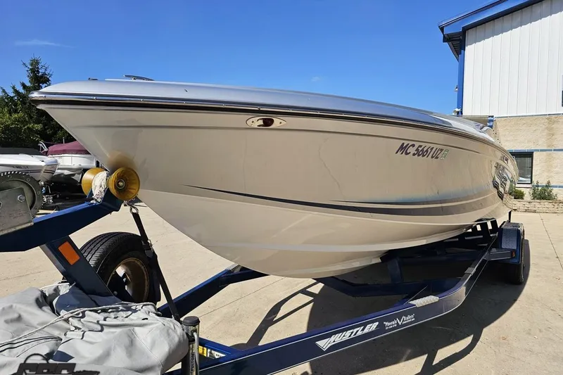 Slide: The Image of 2010 Hustler 266 Classic boat on trailer, parked outdoors in sunny weather. - 17