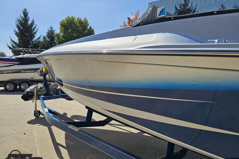 Slide: The Image of 2010 Hustler 266 Classic boat on trailer, sleek design, parked outdoors. - 23