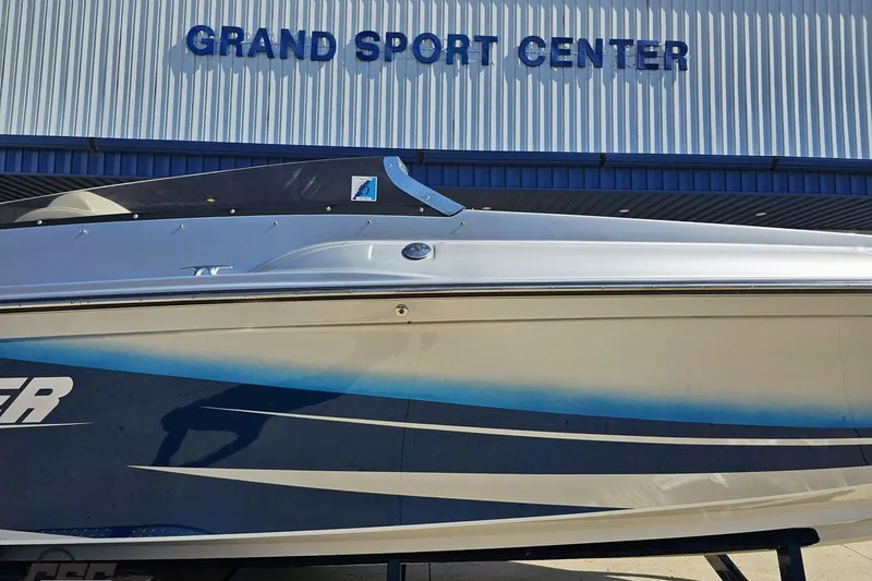 Slide: The Image of 2010 Hustler 266 Classic boat at Grand Sport Center, showcasing sleek design and blue accents. - 4