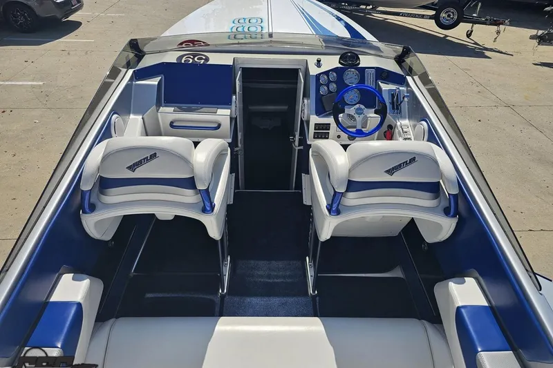 Slide: The Image of Interior of a 2010 Hustler 266 Classic boat with blue and white seating. - 40