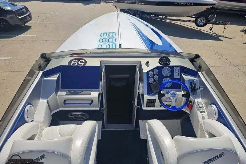 Slide: The Image of 2010 Hustler 266 Classic boat interior with white seats and blue steering wheel. - 41
