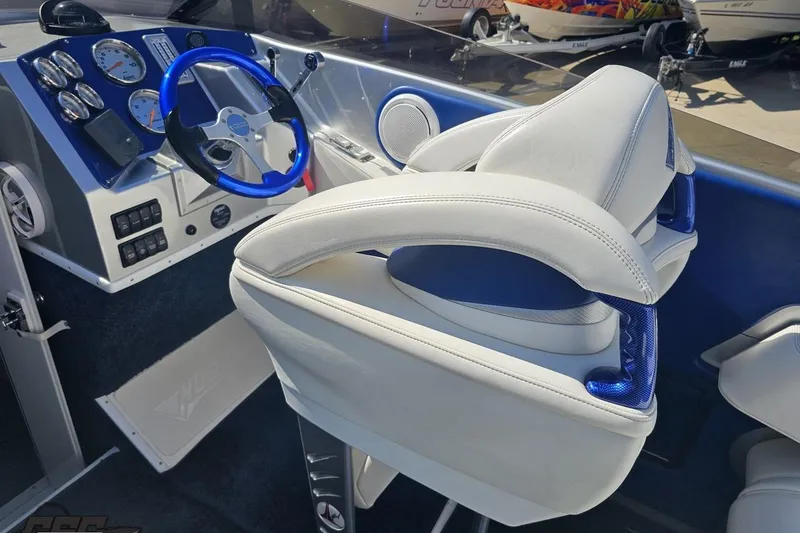Slide: The Image of Interior of 2010 Hustler 266 Classic boat with blue steering wheel and white seating. - 45