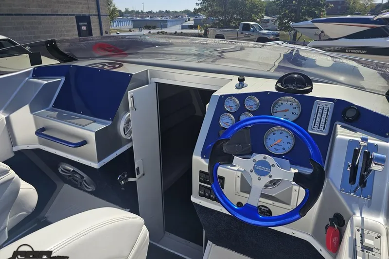 Slide: The Image of 2010 Hustler 266 Classic boat cockpit with blue steering wheel and instrument panel. - 48