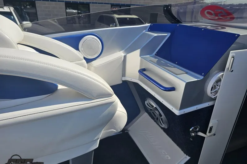 Slide: The Image of Interior of a 2010 Hustler 266 Classic boat with white and blue seating. - 49