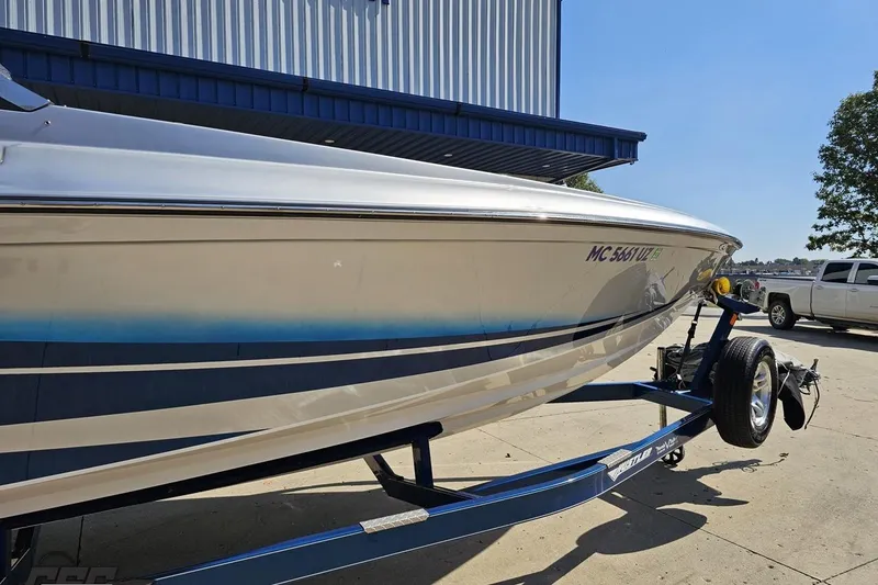 Slide: The Image of 2010 Hustler 266 Classic boat on trailer, parked outdoors near a building. - 5