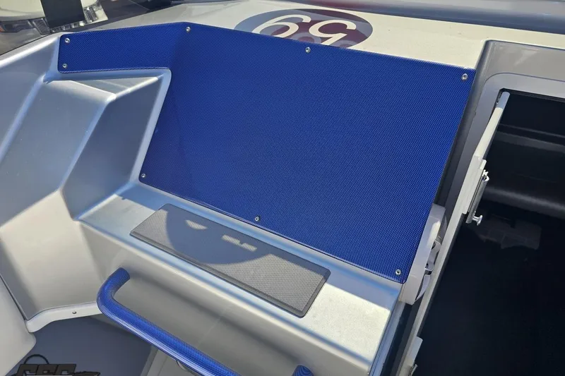 Slide: The Image of Interior of 2010 Hustler 266 Classic boat with blue accents and sleek design. - 51