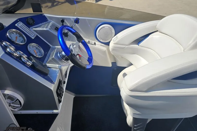 Slide: The Image of 2010 Hustler 266 Classic boat cockpit with blue steering wheel and white seating. - 53