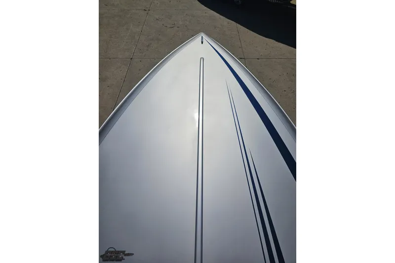 Slide: The Image of Bow view of 2010 Hustler 266 Classic boat with sleek design and blue stripes. - 65