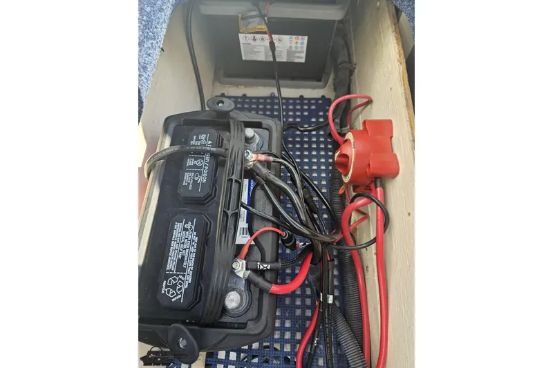 Slide: The Image of Battery compartment of a 2010 Hustler 266 Classic with wiring and connections. - 84