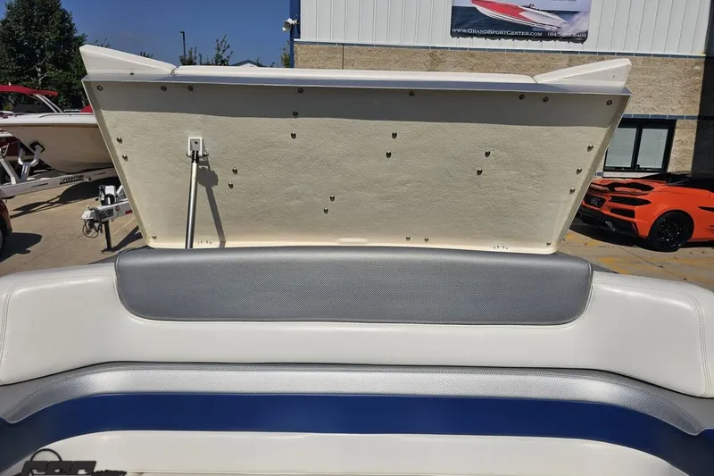 Slide: The Image of 2010 Hustler 266 Classic boat interior with open engine compartment, showcasing seating and upholstery. - 86