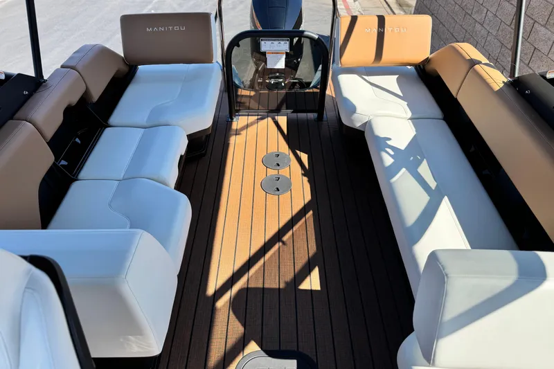 Slide: The Image of 2026 Manitou EXPLORE 22 boat interior with white and tan seating, wooden deck. - 13