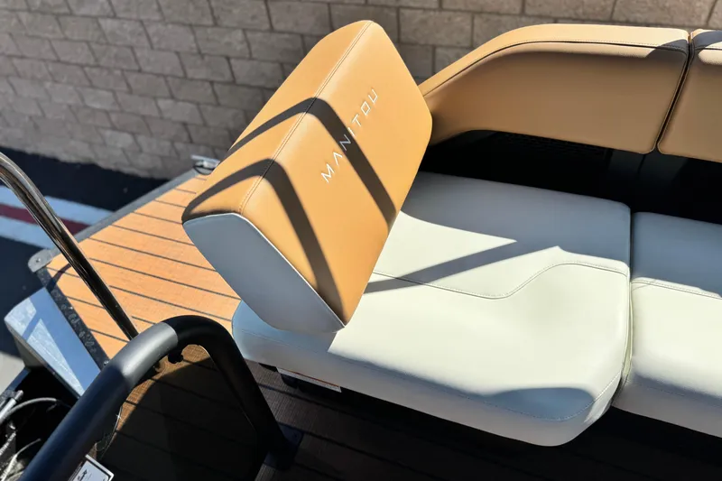 Slide: The Image of 2026 Manitou EXPLORE 22 boat seat with tan and white upholstery, showcasing brand logo. - 17