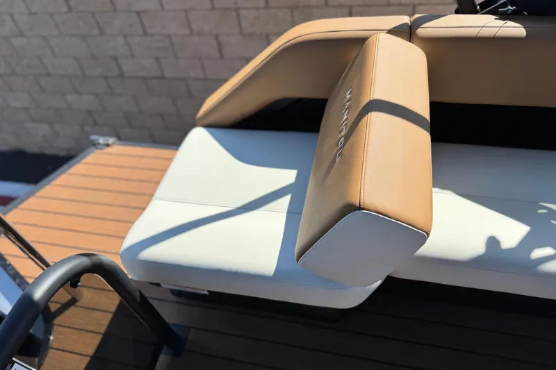 Slide: The Image of 2026 Manitou EXPLORE 22 boat seat with tan and white upholstery, outdoor setting. - 18