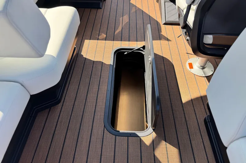 Slide: The Image of 2026 Manitou EXPLORE 22 boat interior with open storage compartment on deck. - 20