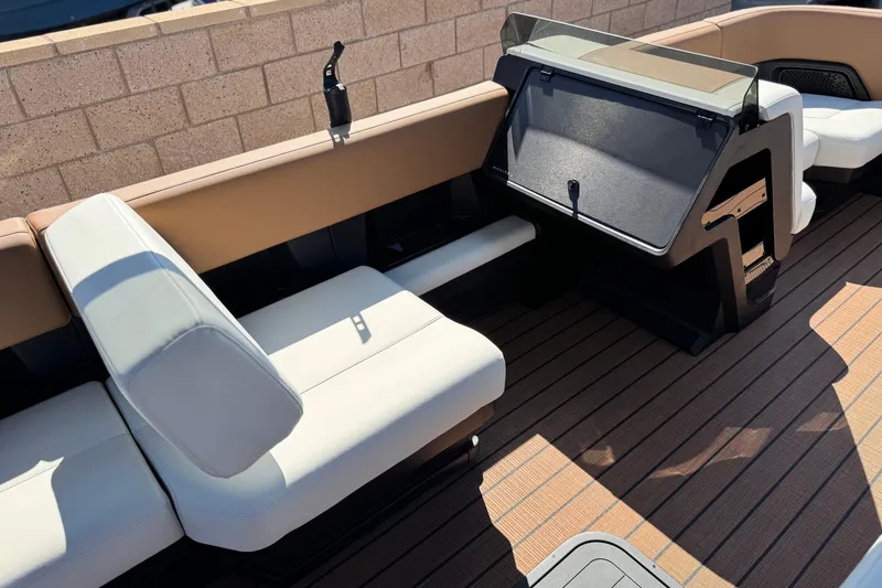 Slide: The Image of 2026 Manitou EXPLORE 22 boat interior with beige seating and modern dashboard design. - 21