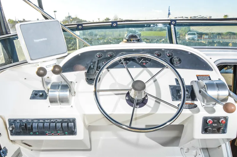 Slide: The Image of 2002 Bayliner 4788 Pilot House Motoryacht helm with steering wheel and controls. - 11