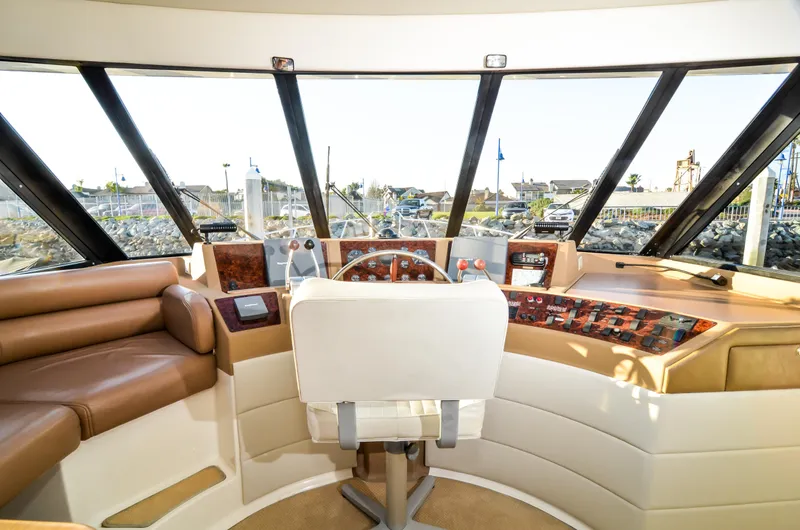 Slide: The Image of 2002 Bayliner 4788 Pilot House Motoryacht helm with panoramic windows and leather seating. - 34