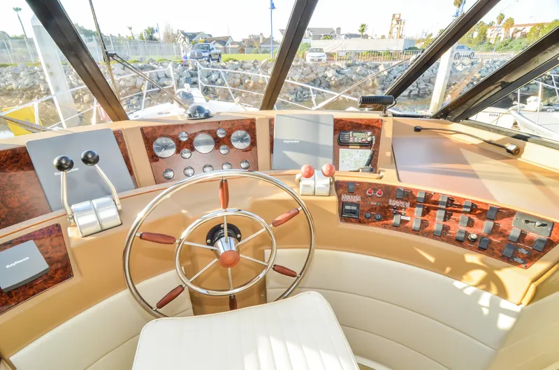 Slide: The Image of 2002 Bayliner 4788 Pilot House Motoryacht helm with steering wheel and control panel. - 35