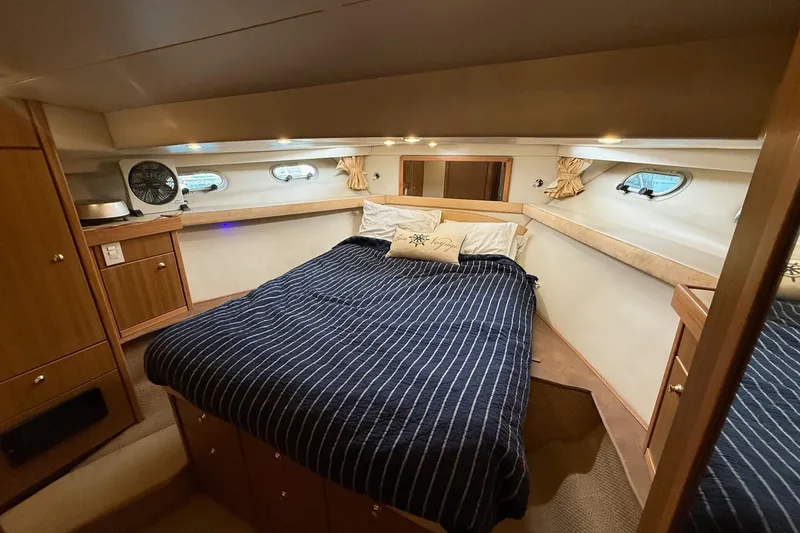 Slide: The Image of Luxurious bedroom interior of 2002 Bayliner 4788 Pilot House Motoryacht with striped bedding. - 43