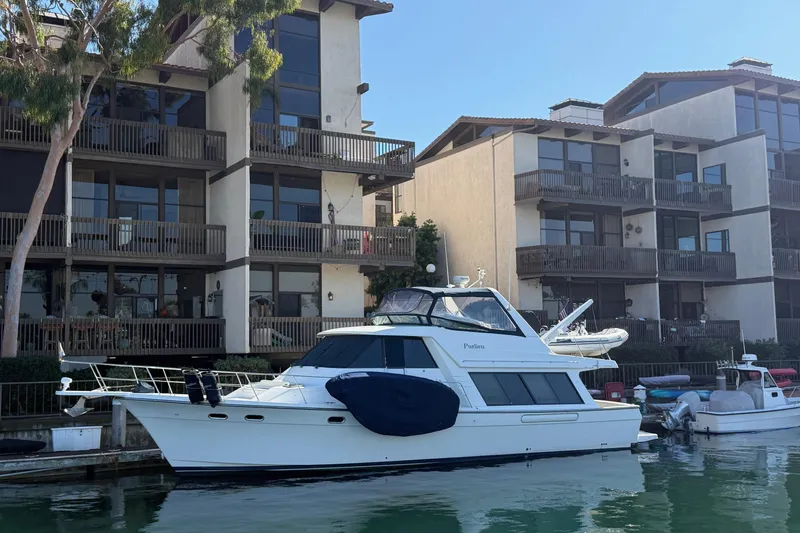 Slide: The Image of 2002 Bayliner 4788 Pilot House Motoryacht docked near waterfront apartments. - 53