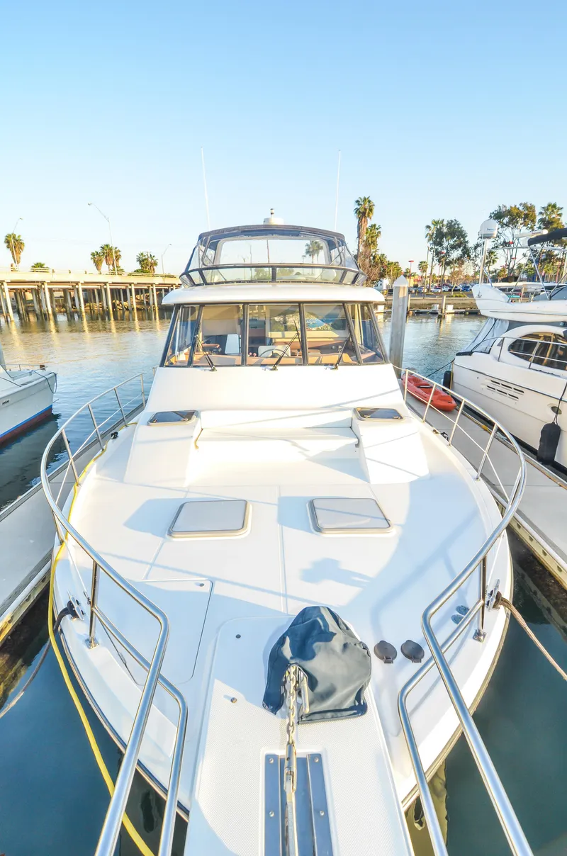 Slide: The Image of 2002 Bayliner 4788 Pilot House Motoryacht docked in a sunny marina. - 7