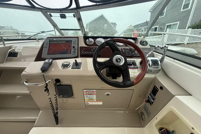Slide: The Image of 2008 Sea Ray 350 Sundancer helm with steering wheel, navigation system, and control panel. - 18