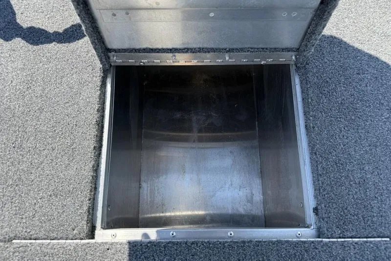 Slide: The Image of Open storage compartment in 2020 Tracker Pro 170 boat, featuring carpeted interior. - 11