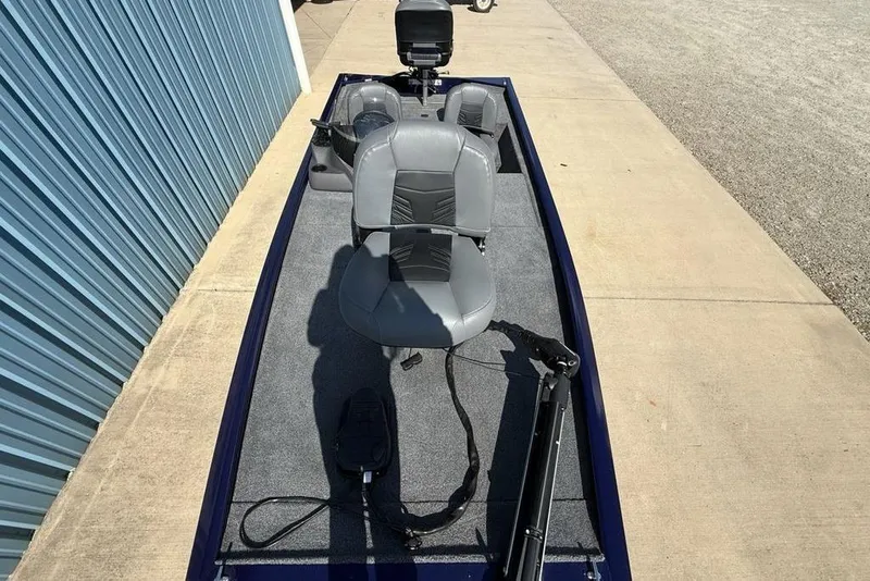 Slide: The Image of 2020 Tracker Pro 170 boat with gray seats, parked on concrete near blue building. - 22