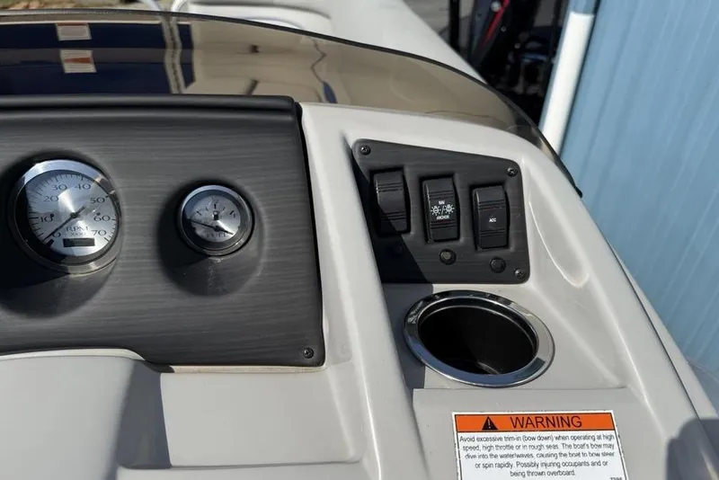 Slide: The Image of Dashboard of 2023 Bennington 22 boat with gauges, switches, and warning label. - 16