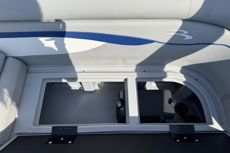 Slide: The Image of 2023 Bennington 22 boat storage compartment with open lid, featuring sleek interior design. - 18