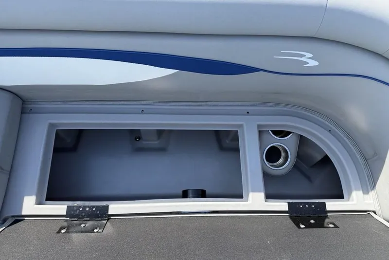 Slide: The Image of 2023 Bennington 22 boat storage compartment with cup holders and sleek interior design. - 3