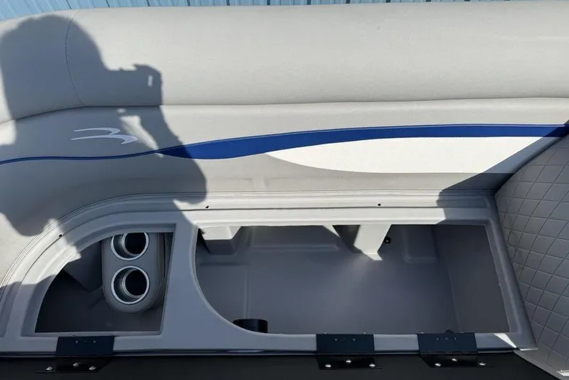 Slide: The Image of 2023 Bennington 22 boat seat storage with cup holders, featuring gray and blue upholstery. - 8