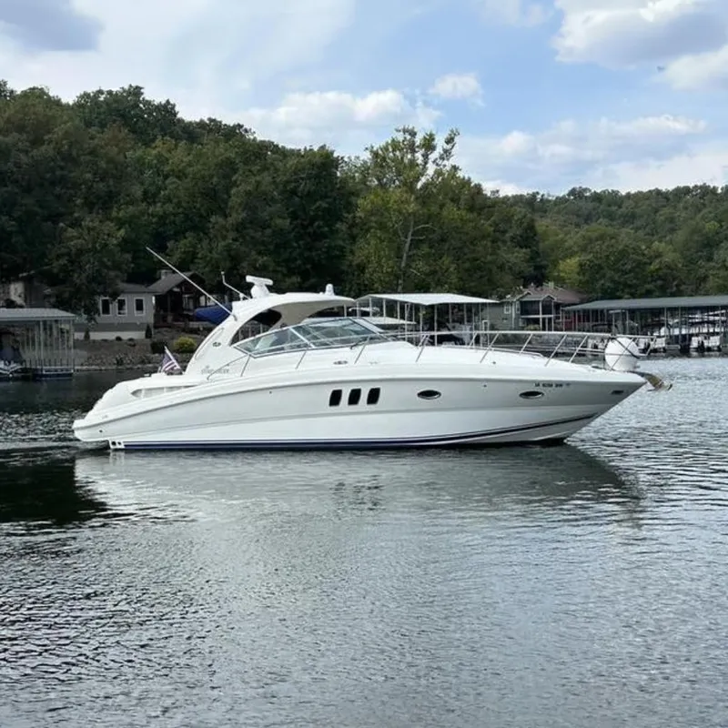 The Image of 2006 Sea Ray 38 Sundancer yacht on a calm lake with wooded shoreline. - 0