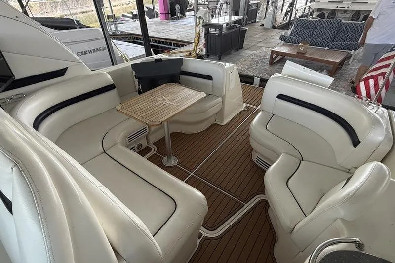 Slide: The Image of 2006 Sea Ray 38 Sundancer interior with white seating and wooden flooring. - 10