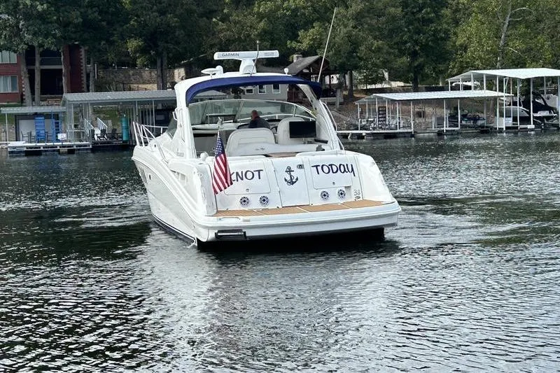 Slide: The Image of 2006 Sea Ray 38 Sundancer yacht on a lake, displaying "Knot Today" with an American flag. - 12