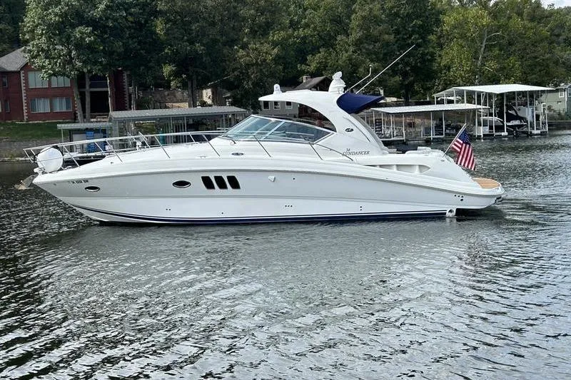 Slide: The Image of 2006 Sea Ray 38 Sundancer yacht on a serene lake with lush greenery. - 2