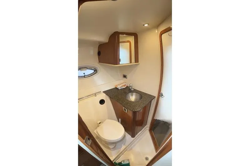 Slide: The Image of 2006 Sea Ray 38 Sundancer bathroom with sink, toilet, and storage cabinet. - 8