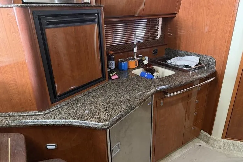 Slide: The Image of 2006 Sea Ray 38 Sundancer yacht kitchen with wood cabinetry and granite countertop. - 9