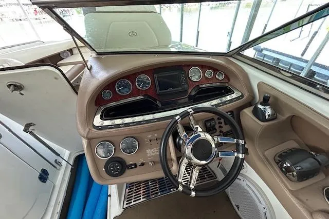 Slide: The Image of Interior view of a 2011 Cobalt 302 boat dashboard with steering wheel and controls. - 11