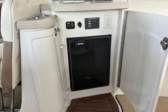 Slide: The Image of 2011 Cobalt 302 boat interior with mini fridge and control panel. - 21