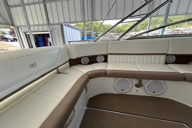 Slide: The Image of 2011 Cobalt 302 boat interior with white and brown seating under a metal canopy. - 4