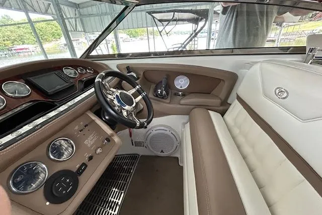 Slide: The Image of 2011 Cobalt 302 boat interior with steering wheel, gauges, and beige seating. - 5