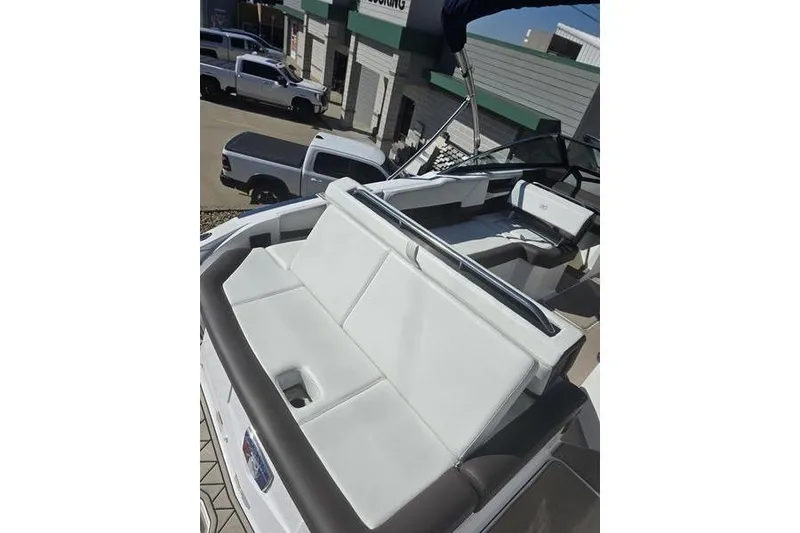 Slide: The Image of 2022 Cobalt R4 boat with white seating and sleek design in a dealership setting. - 10